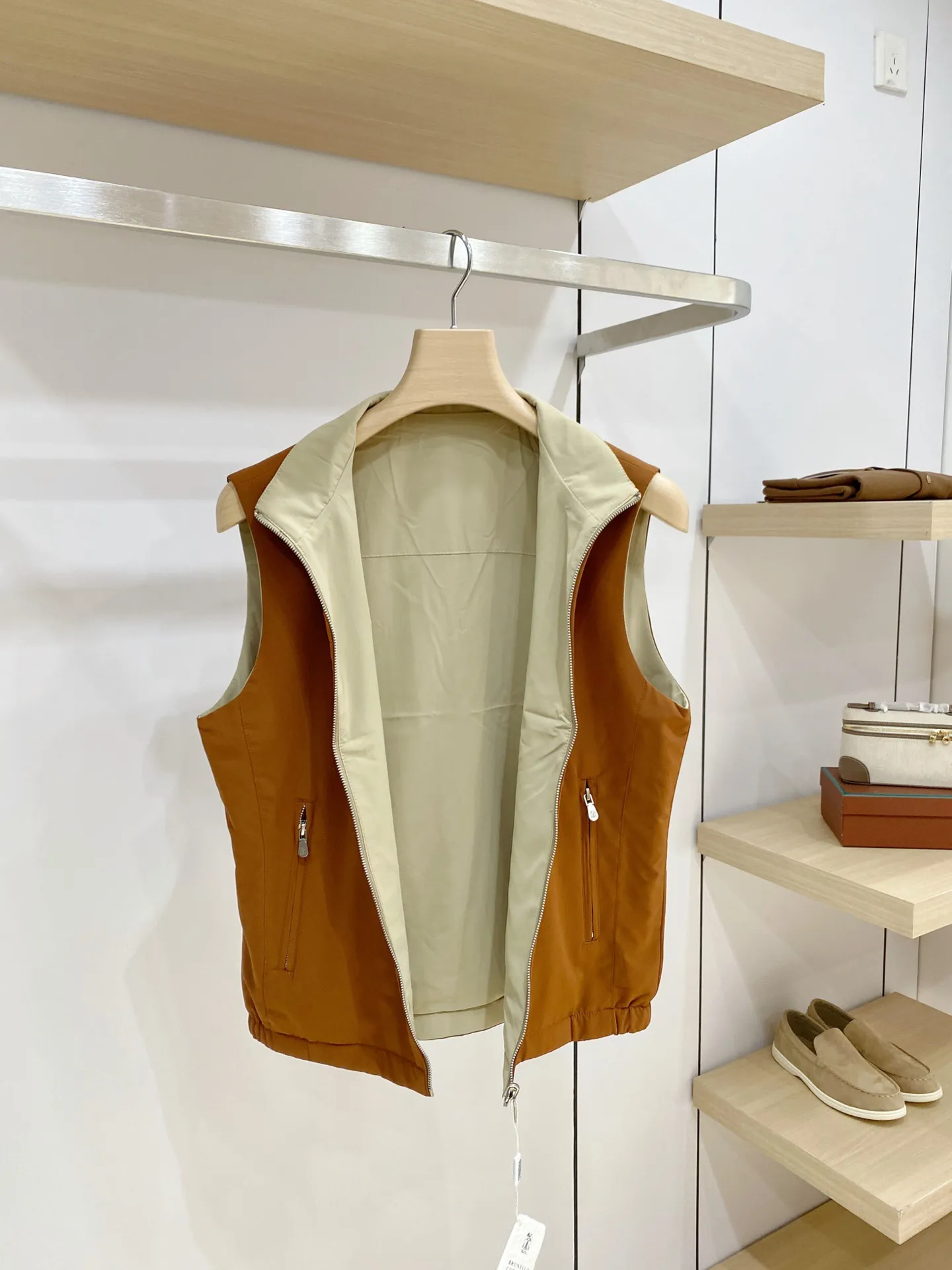BC Reversible Stand Collar Men's Vest Style: Simple stand collar sleeveless vest, fitted straight cut, elastic hem at the hem, not tight or pressing. The sleeveless design does not restrict arm movement and can be worn both inside and outside. It is suitable for layering shirts, sweaters, and long-sleeved T-shirts. It can be used for business, leisure, and daily travel. It is highly tolerant to a variety of body shapes. Fabric: Made of high-density anti-wrinkle functional fabric, it feels smooth and crisp, has certain windproof properties, is not easy to wrinkle, and is easy to care for. The front and back sides are in different colors, the fabric has the same texture, is light and moderate, and is suitable for the transitional seasons from spring to autumn. Craftsmanship: The metal zipper is smooth and durable, and the zipper pockets on both sides ensure safe and secure placement of items; the exquisite shield-shaped embroidered logo on the chest is low-key and luxurious. The whole piece is neatly cut, the edges and corners are clean, and the workmanship inside and outside is equally exquisite. Lining details (double-sided structure) The two sides can be worn directly outside without a separate lining cloth, and the colors on the two sides are in contrast to each other. The splicing and binding are precision lock-stitched, with no excess threads, and the seams are smooth and snug; the fabric feels delicate, smooth to put on and take off, and will not scratch the inner clothing; the hem is elastic and solid, and will not be easily deformed after repeated pulling. Both sides can be worn independently as fronts to achieve two outfit effects. Color: Cream White/burgundy, caramel/beige gray, Black/Navy Blue, Navy Blue/burgundy, multiple sets of double-sided contrasting colors, the tone is calm and high-end, suitable for all kinds of bottoms. Sizes: M‑4XL